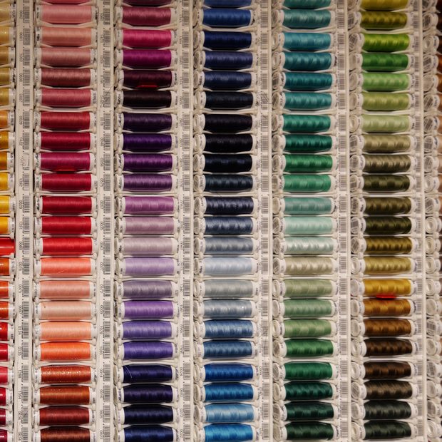 Nähfaden in vielen Farben an der Wand