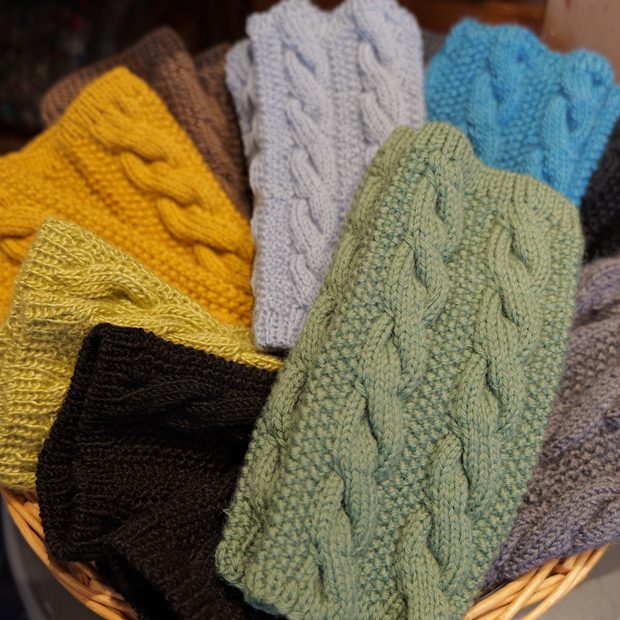 Gestrickte Stirnbänder mit Zopfmuster in einem Korb